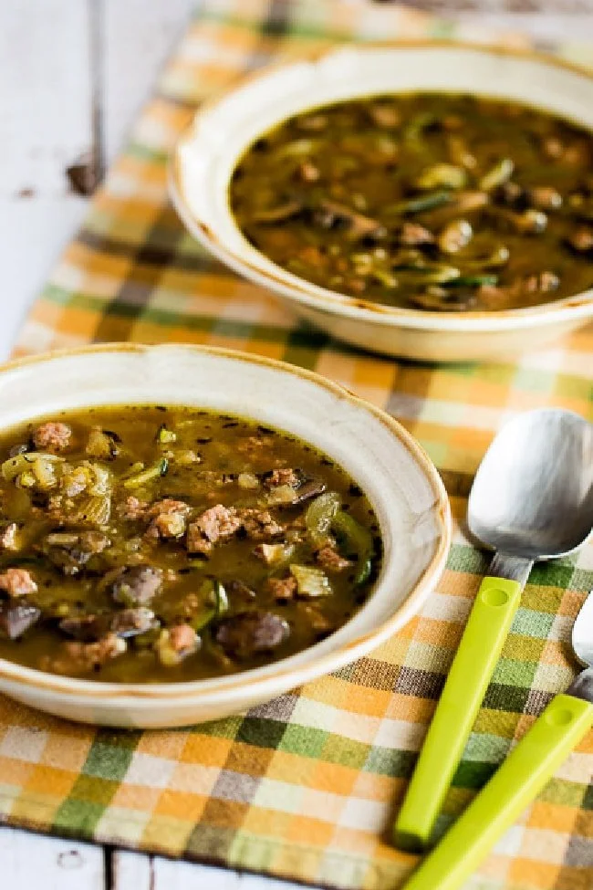 A bowl of hearty turkey mushroom soup topped with fresh herbs.